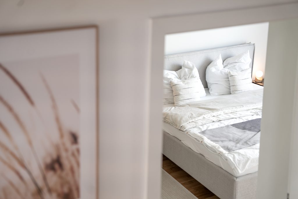 Blick durch den Türrahmen des Schlafzimmers auf das Bett.