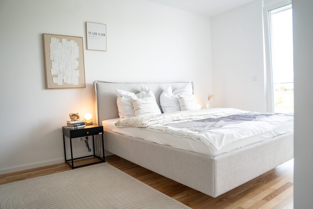 Ein helles Schlafzimmer mit bodentiefen Fenstern.